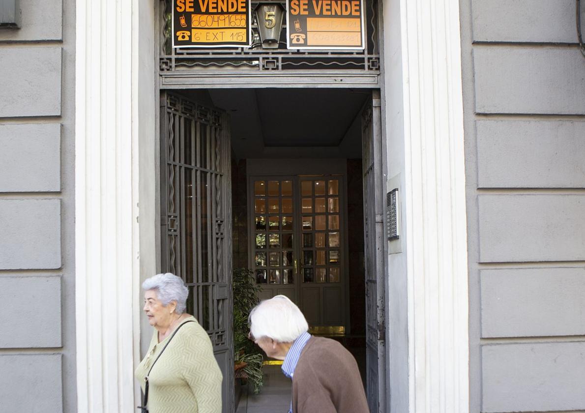 Ancianos en un edificio con pisos en venta.