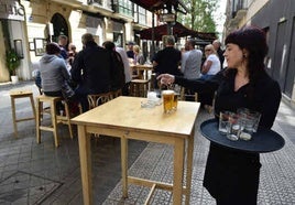 Una camarera sirviendo en una terraza.