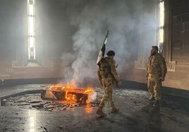 Combatientes rebeldes junto a la tumba en llamas del difunto presidente de Siria, Hafez al Assad.