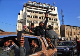 Combatientes sirios celebran la victoria de los rebeldes encabezados por Al Golani cerca de la Torre del Reloj en la ciudad de Homs.