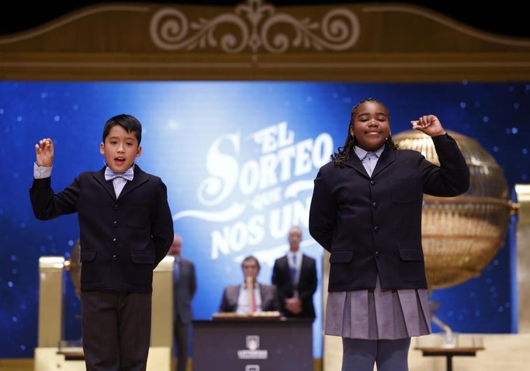 Los niños de la Residencia San Ildefonso de Madrid Ainhoa Rosero (d) y Axiel Kyron (i) muestran el 77.768, un cuarto premio