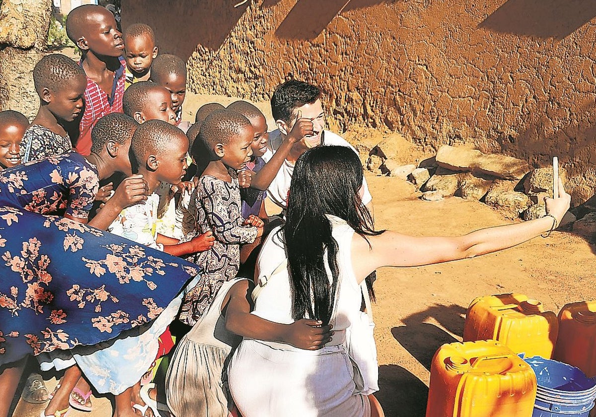 Una pareja de visitantes se hace un selfie en un poblado de Mwanza.