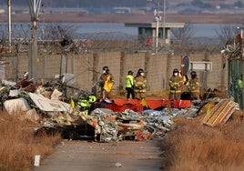 Operarios entre los restos del avión siniestrado en el aeropuerto surcoreano de Muan.