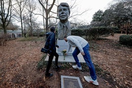 Dos jóvenes depositan un ramo delante del busto de Jimmy Carter en su fundación de Atlanta.