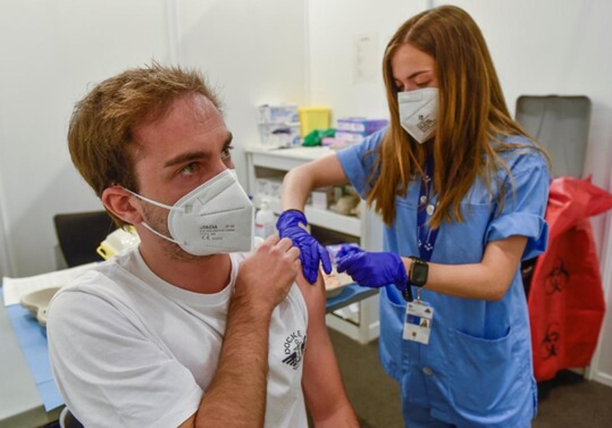 Un joven es vacunado de la gripe en un centro de salud.