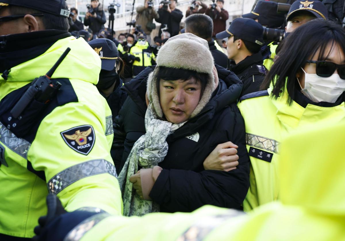 La Policía detiene a una simpatizante de Yoon Suk-yeol en las protestas de Seúl.