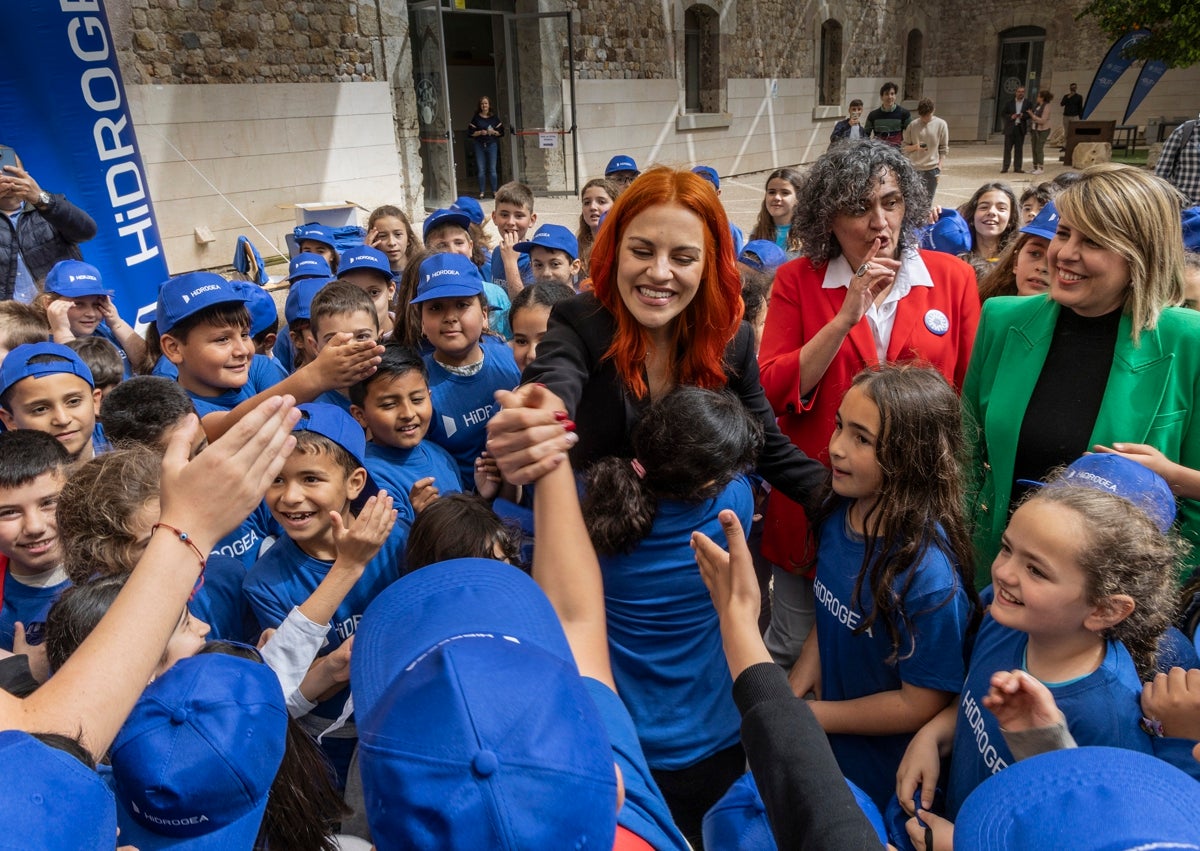 Imagen secundaria 1 - De arriba a abajo, la astronauta leonesa en la sede central de Penguin, la editorial de 'Órbitas'; con niños de un instituto asturiano; y con el uniforme del Centro Europeo de Astronautas de la Agencia Espacial Europea. 