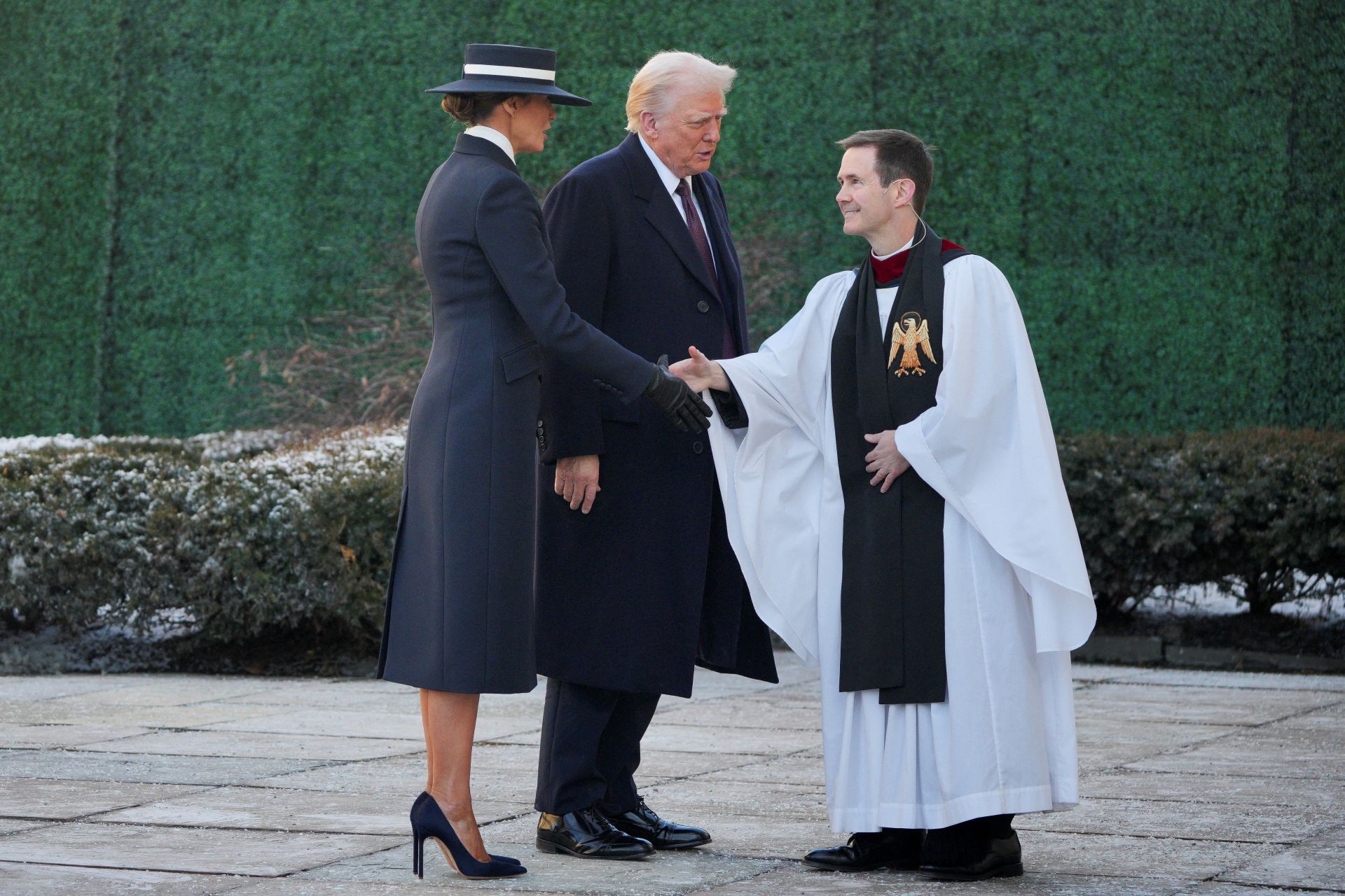 Trump y su esposa Melania saludan al sacerdote encargado de oficiar la misa en la iglesia de St. John.