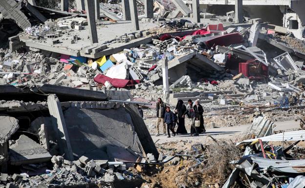 Una familia palestina camina entre las ruinas de un barrio de Gaza bombardeado por Israel.