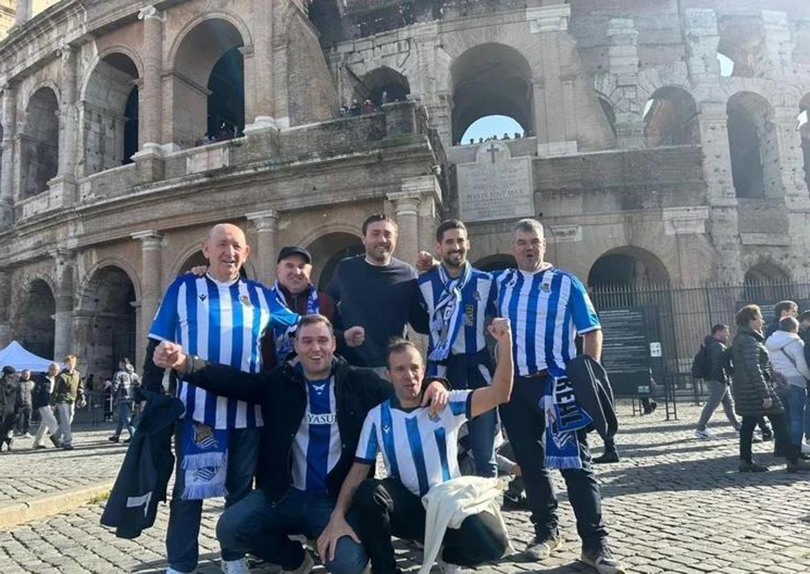 Aficionados de la Real posan junto al Coliseo de Roma.