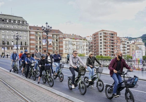 Turistas extranjeros visitando Bilbao en bici.