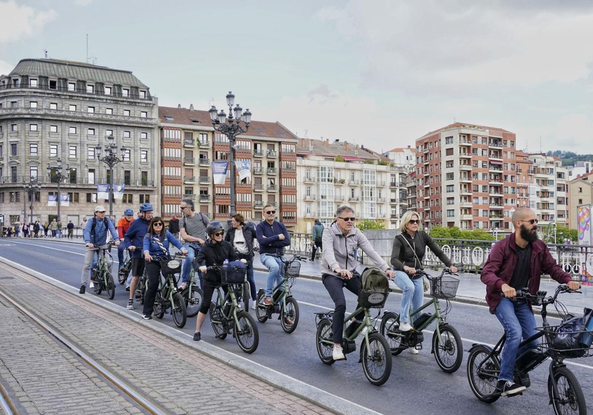 Turistas extranjeros visitando Bilbao en bici.