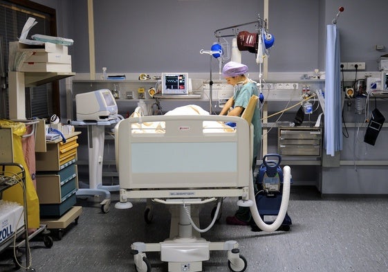 Una enfermera cuida de una paciente en una sala de recuperación de un hospital.