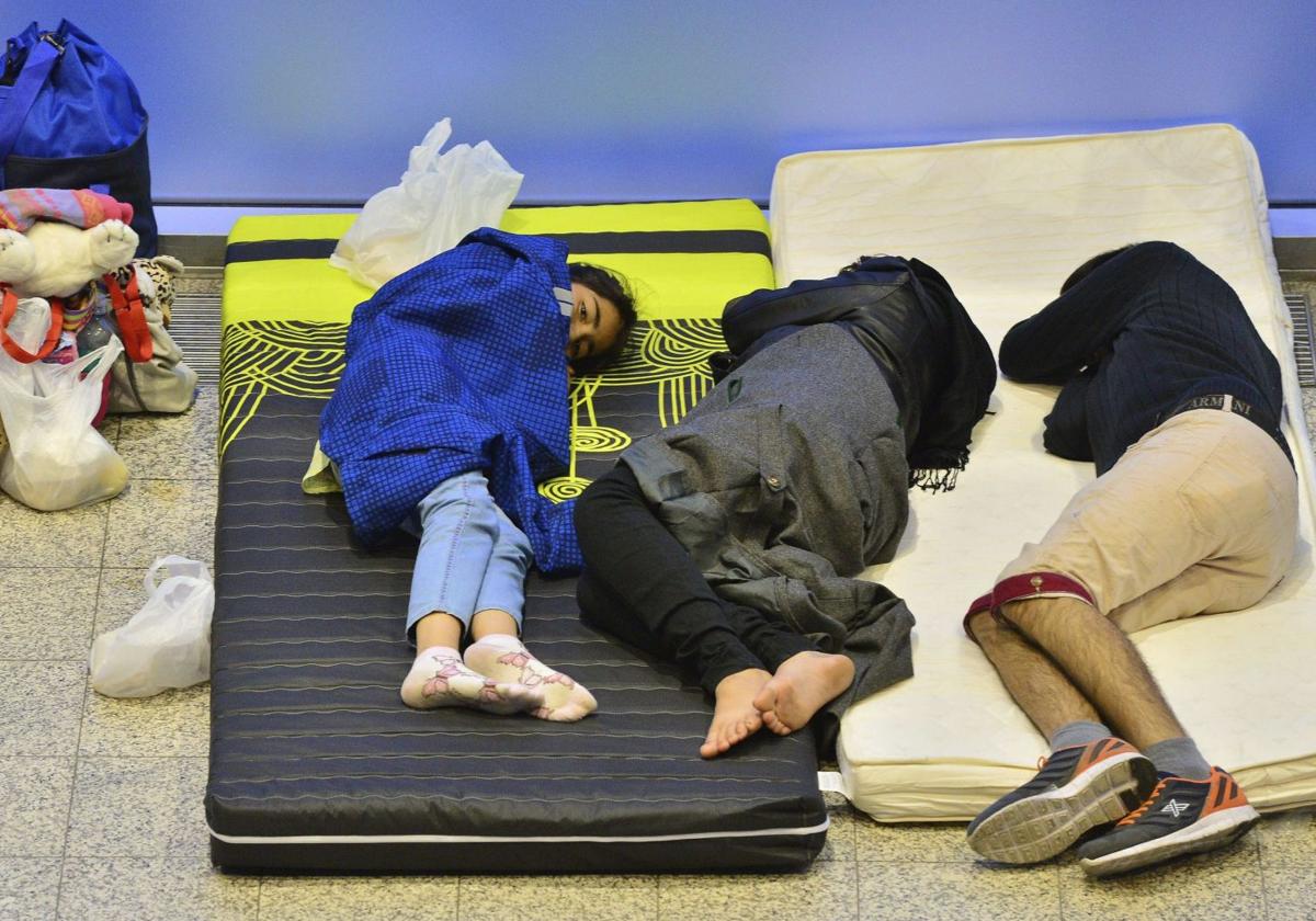 Una familia de refugiados descansa sobre dos colchones en un recinto ferial de la ciudad de Erfurt (Alemania), en 2015.