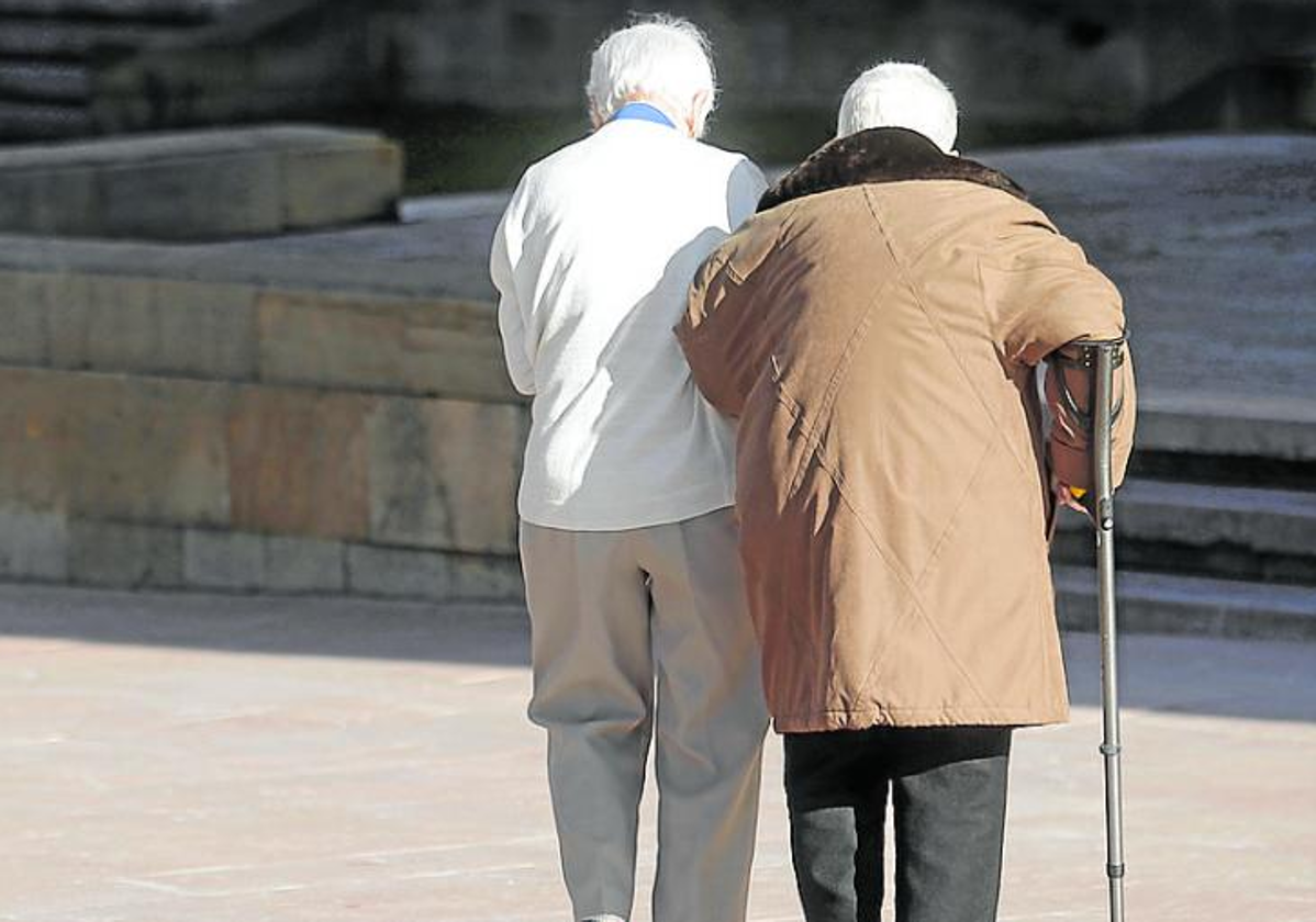 Dos personas mayores pasean por la calle