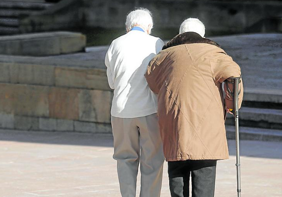 Dos personas mayores pasean por la calle