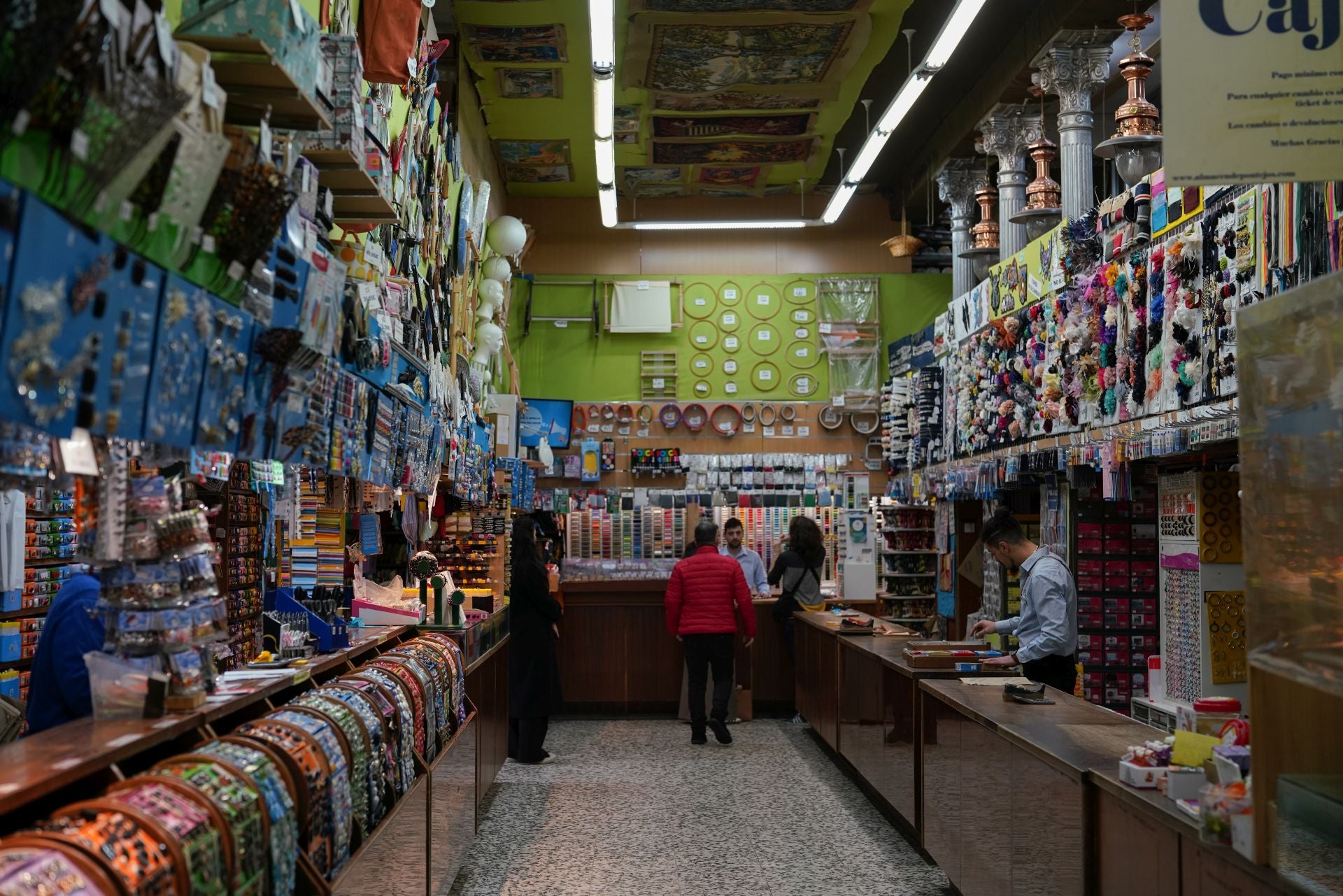 Al fondo de la imagen, una pared forrada con algunos de los más de 600 colores de hilos que ofrecen. 