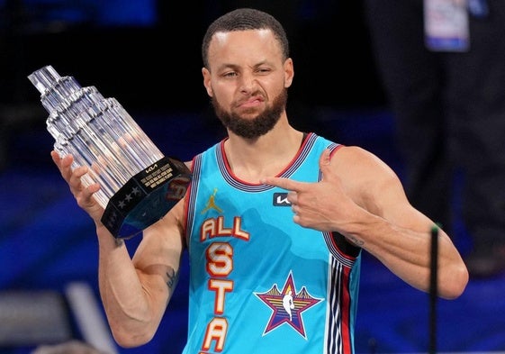 Stephen Curry levanta el trofeo que acredita al equipo de Shaquille O'Neal como ganador del All-Star.