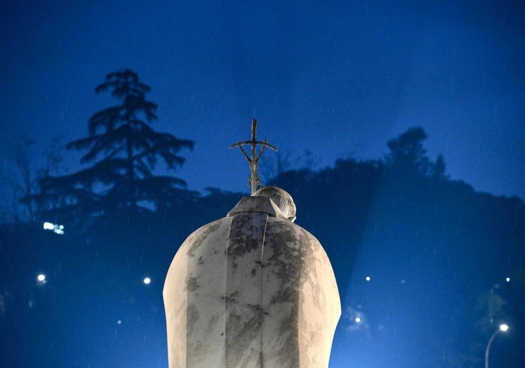 La estatua del Papa Juan Pablo II iluminadaen el exterior del Hospital Agostino Gemelli donde se encuentra internado el Papa Francisco en Roma.