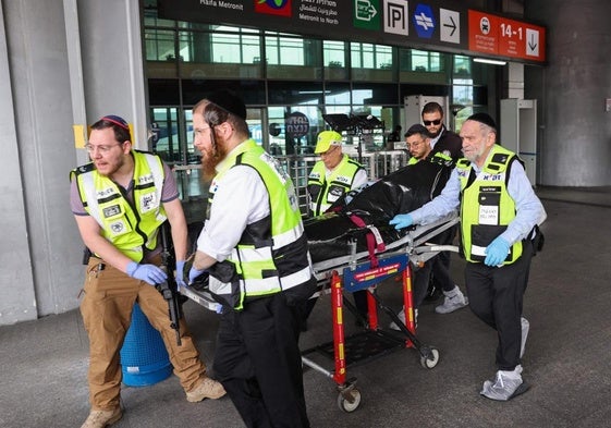 Miembros de los servicios de emergencias transportan el cuerpo del presunto autor del apuñalamiento en una estación de autobuses en Haifa.