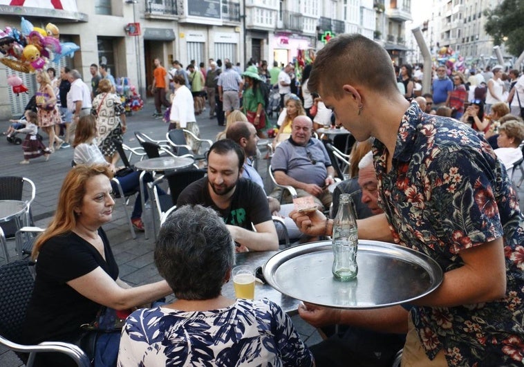 Un camarero atiende unas mesas en una terraza