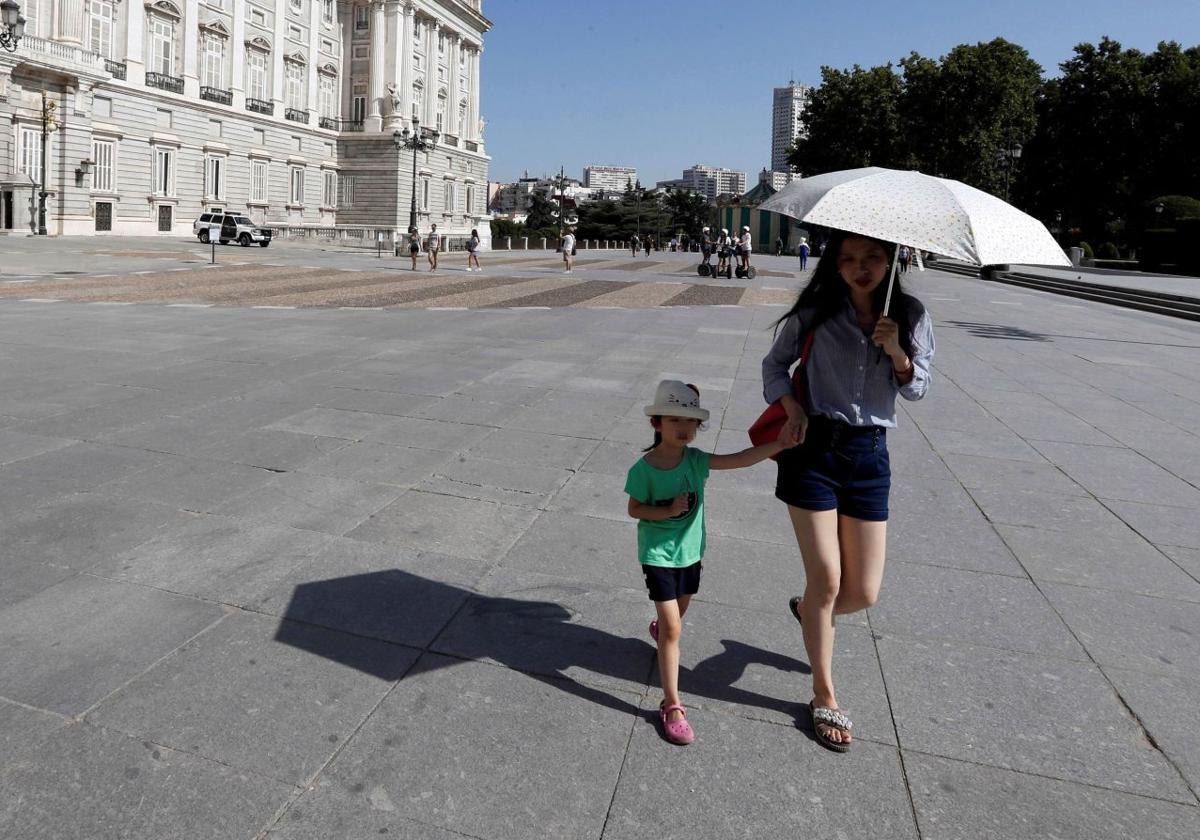 Una niña pasea de la mano con su madre durante una ola de calor del pasado verano en Madrid.