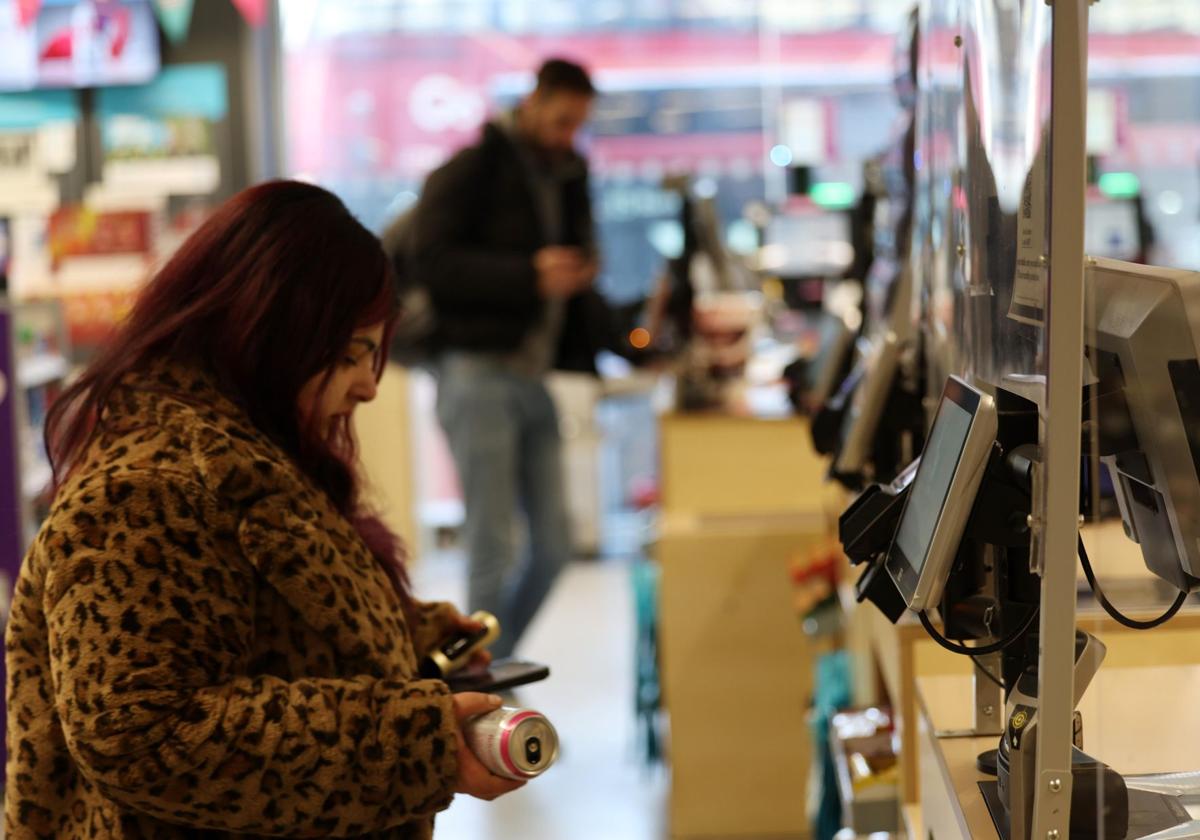 Una mujer procede a cobrarse en una caja de autopago de una tienda de Londres.