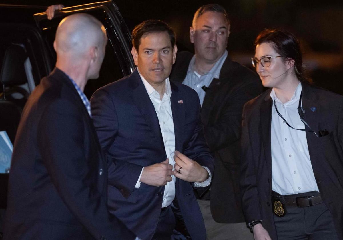 El secretario de Estado de Estados Unidos, Marco Rubio (centro), antes de entrar en el avión militar.