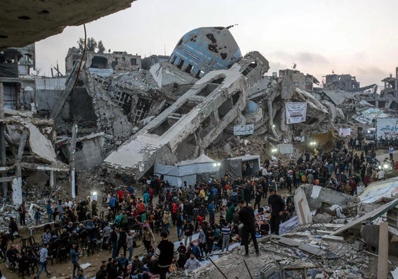 Residentes de la localidad de Beit Lahiya, en el norte de Gaza, reunidos en torno a las ruinas de edificios bombardeados por Israel.