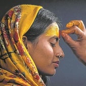 Un sadhu dibuja en la frente de una devota el bindi, símbolo del instinto, la intuición y la clarividencia.