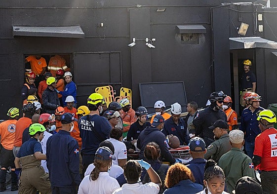 Integrantes del cuerpo de bomberos y de rescate evacúan a un herido este martes en la discoteca Jet Set en Santo Domingo (República Dominicana).