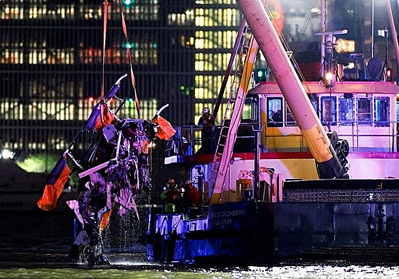 Un barco-grúa saca del río Hudson, en Nueva York, los restos del helicóptero que se estrelló el jueves con una familia española a bordo.