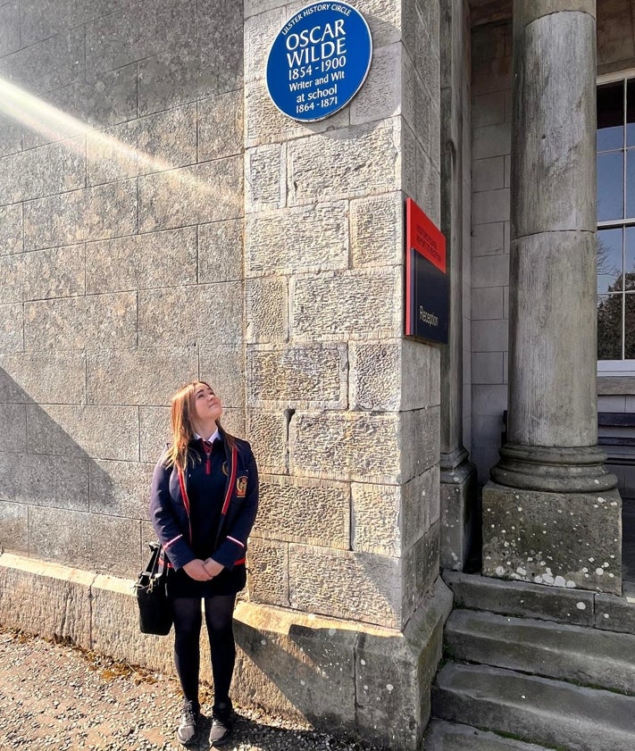 Imagen secundaria 2 - Seán Doran, director del festival In our Dreams en Enniskillen. Cuadro de Honor del internado Portora Royal School y una de su alumnas actuales ante la placa que recuera el paso de Wilde por la escuela entre 1864 y 1971.