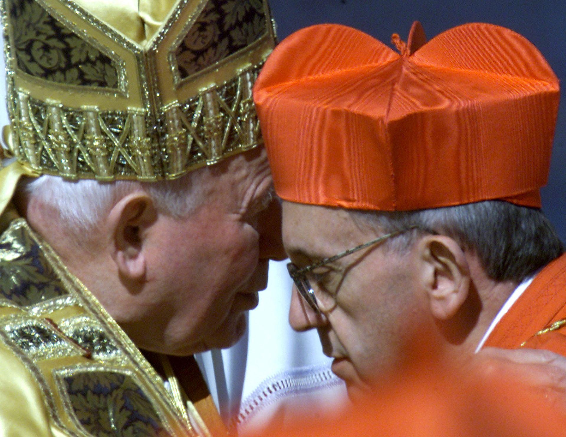 El nuevo cardenal argentino Jorge Mario Bergoglio besa al papa Juan Pablo II después de recibir la boina roja, un sombrero rojo de cuatro picos, durante la ceremonia del Consistorio en la Plaza de San Pedro el 21 de febrero de 2001.