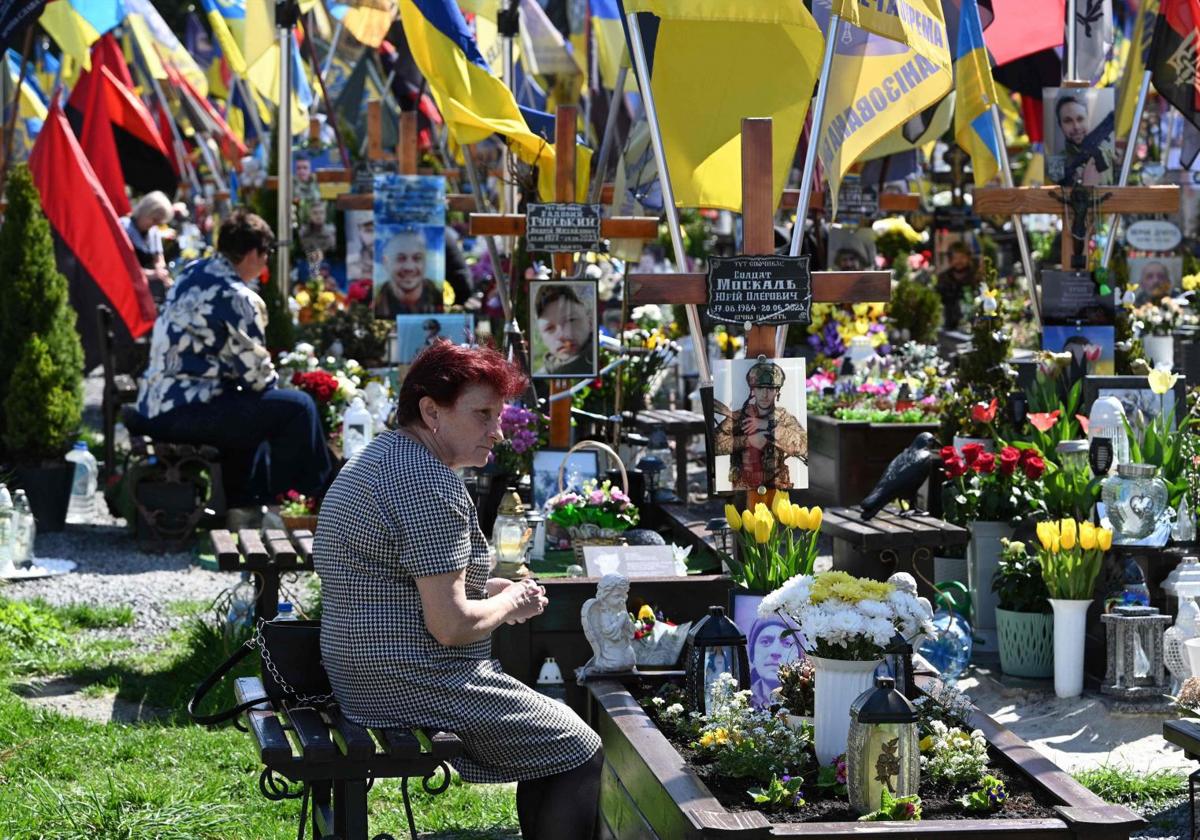 Varias madres velan por sus hijos, muertos en combate, en un cementerio de Ucrania.