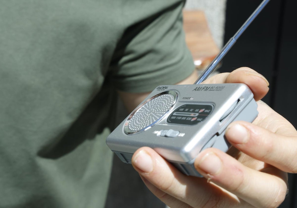 A citizen follows the blackout's progress yesterday using a battery-powered radio.