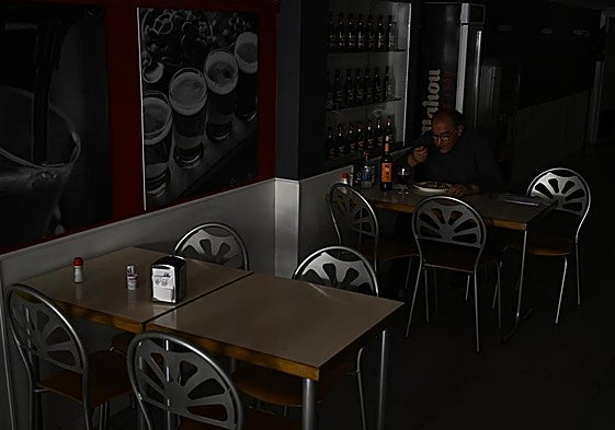 Un hombre comiendo en un restaurante durante el apagón este lunes.