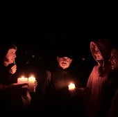 Un grupo de personas se alumbra con velas durante el apagón.