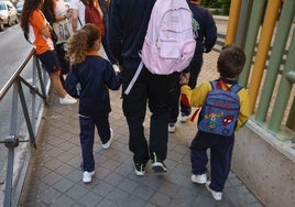 Un padre acerca a sus hijos al Colegio Nazaret, en el madrileño distrito de Carabanchel.