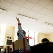 Un niño levanta el brazo para participar durante una clase.