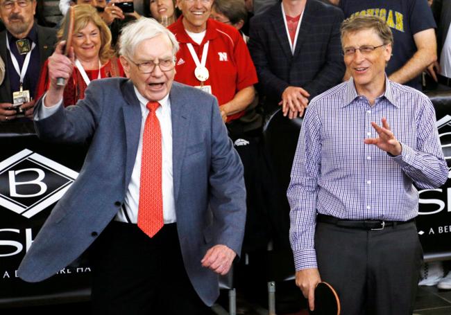Warren Buffett hace un gesto antes de jugar una partida de tenis de mesa con el cofundador de Microsoft, Bill Gates, en 2013, al día siguiente de la junta anual de la compañía.