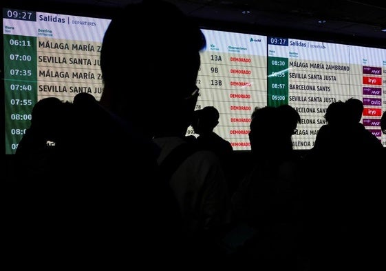Pasajeros frente al panel de llegadas de la estación de Atocha.