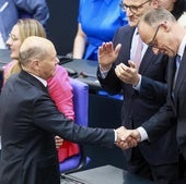 El socialdemócrata Olaf Scholz (izquierda) felicita a su sucesor al frente de la cancillería, el conservador Friedrich Merz, tras su investidura ayer en el Bundestag.
