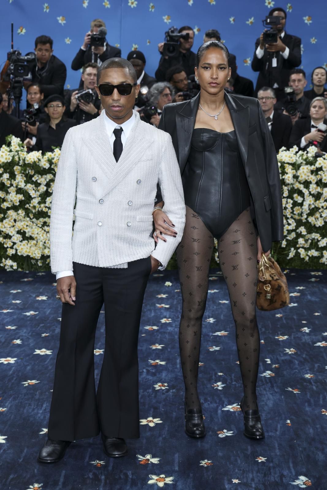 Pharrell Williams, con una chaqueta con 15.000 perlas de Louis Vuitton, firma de la que es director creativo, y su mujer, la diseñadora de moda Helen Lasichanh, con un 'look' muy similar al de Haley Bieber. 