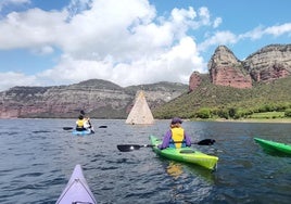 Piragüistas navegan esta semana en el pantano de Sau (Barcelona), junto a la iglesia de Sant Romà, donde ya solo se ve el tejado del campanario.