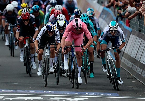 Mads Pedersen, de rosa, cruza la línea de meta con Edoardo Zambanini a su izquierda.