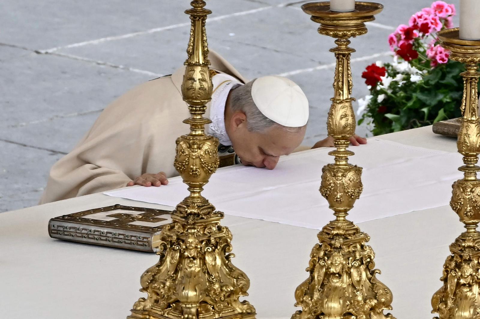 El papa León xiv besa el altar.