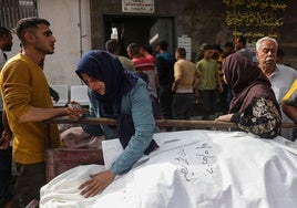 Familias palestinas lloran junto a los cadáveres de sus seres queridos fallecidos en ataques israelíes en Gaza.