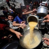 Varios gazatíes tratan de recoger algo de comida en Jabalia, en el norte de la Franja.