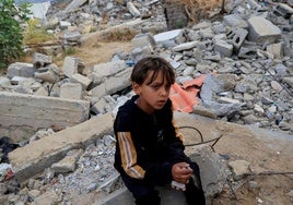Un niño palestino se sienta sobre escombros tras un ataque israelí, en Khan Younis, al sur de la Franja de Gaza.
